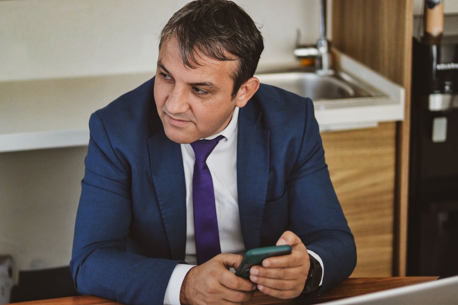 Entrepreneur congolais gérant sa boutique en ligne sur smartphone dans un bureau moderne à Kinshasa