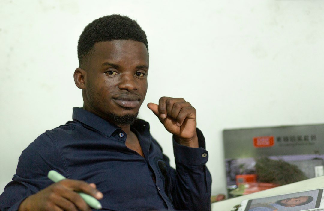 Professionnel du marketing digital analysant une landing page sur ordinateur dans un bureau à Kinshasa